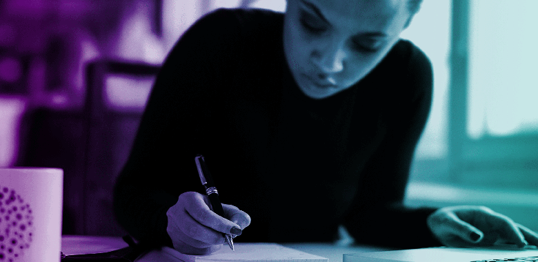 A woman writes on a notepad.