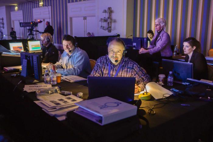 Mark Mallchok, Brella's Senior Event Strategist, works with other event tech team members behind-the-scenes at a live event.