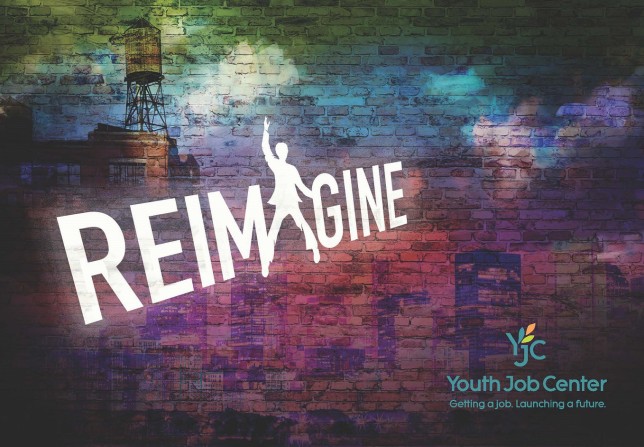 Video still from the Brella Productions produced Youth Job Center (YJC) Gala video featuring the gala theme logo, Reimagine, projected against brick wall.